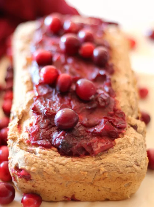 Homemade cranberry bread topped with whole cranberries – a festive idea for what to make with Thanksgiving leftovers and recipes that stretch your budget.