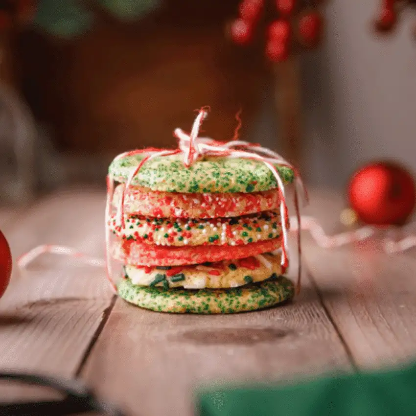 Stack of colorful Christmas cookies tied with string, a cheerful DIY Christmas gift idea featuring cookies and bars.