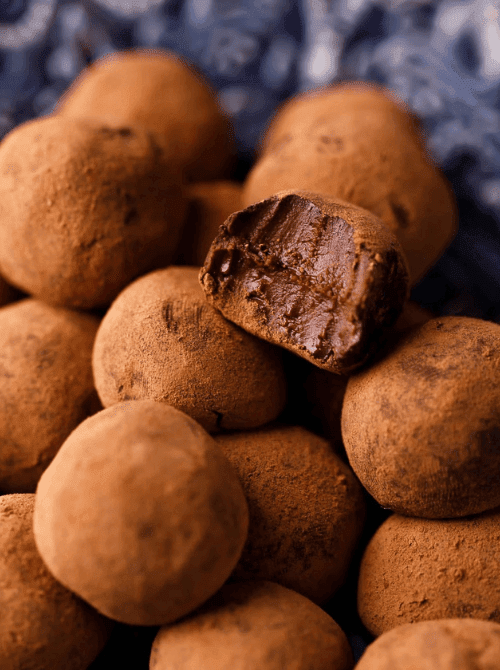 Rich dark chocolate rum truffles dusted in cocoa powder, a decadent DIY Christmas gift and easy edible gift idea for holiday gifting.