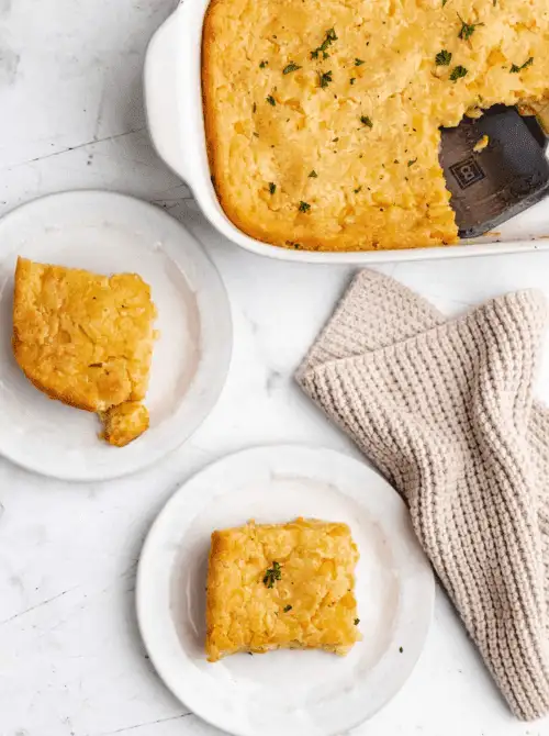 Golden, buttery corn casserole sliced into squares and served on small white plates—this Budget-Friendly Thanksgiving Vegetable Side is creamy, cozy, and perfect for sharing.