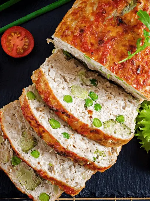 Sliced turkey loaf with vegetables like broccoli and peas baked inside — a hearty and budget-friendly idea for what to make with Thanksgiving leftovers and one of the best easy turkey recipes for family meals.