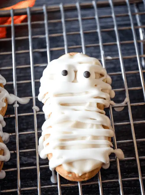Easy Nutter Butter mummy cookies drizzled with white icing and candy eyes—perfect make-ahead Halloween party food for kids and spooky dessert tables.