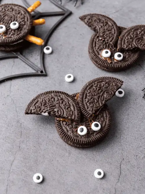 No-Bake Halloween Treats made with chocolate sandwich cookies, candy eyes, and pretzel sticks to resemble spooky bats and spiders — fun and easy edible crafts for Halloween.
