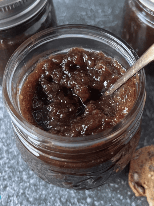 Homemade fig jam in a mason jar with spoon, a rich and flavorful mason jar recipe that makes a thoughtful DIY Christmas gift.