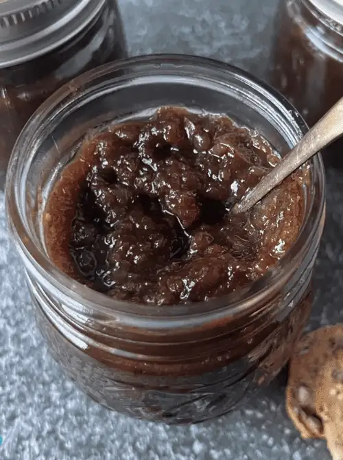 Homemade fig jam in a mason jar with spoon, a rich and flavorful mason jar recipe that makes a thoughtful DIY Christmas gift.