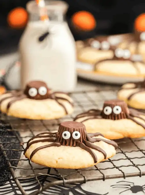 Peanut butter spider cookies with candy eyes and chocolate drizzle—an adorable make-ahead Halloween party food that’s perfect for spooky dessert trays.
