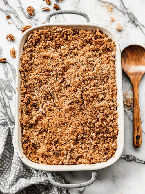Sweet potato casserole with a golden pecan crumble topping in a rectangular baking dish, featured in Budget-Friendly Thanksgiving Sides and Easy Potato Recipes for a classic holiday favorite.