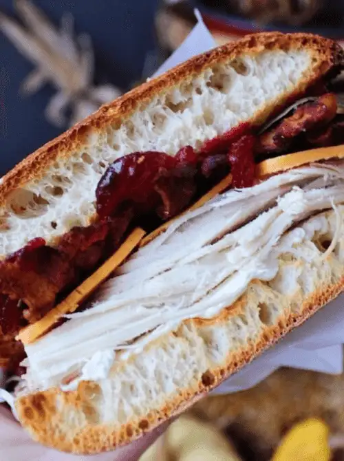 Thick turkey cranberry sandwich layered with bacon, cheese, and fresh bread – a classic idea for what to make with Thanksgiving leftovers and recipes that stretch your budget.
