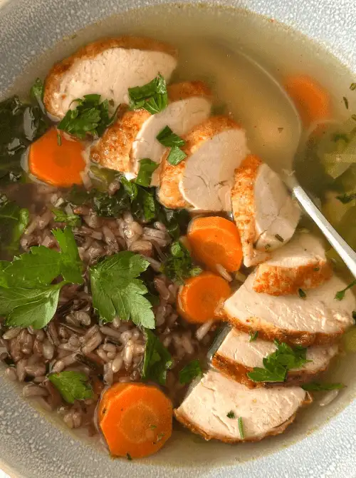 Bowl of turkey, wild rice, carrots, and fresh parsley in a light broth — a wholesome idea for what to make with Thanksgiving leftovers and one of the best easy turkey recipes for a cozy meal.