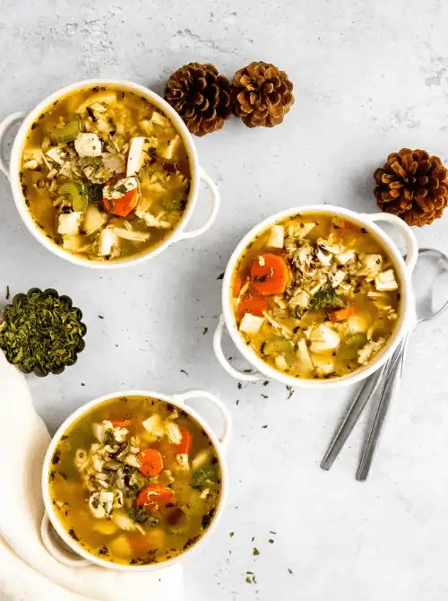 Three bowls of turkey and rice soup with carrots, celery, and herbs — a comforting idea for what to make with Thanksgiving leftovers and one of the best easy turkey recipes for family dinners.