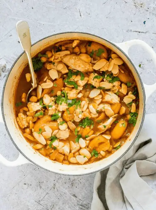 Dutch oven filled with leftover turkey stew made with apricots, almonds, and herbs — a flavorful twist on what to make with Thanksgiving leftovers and a unique option for easy turkey recipes.