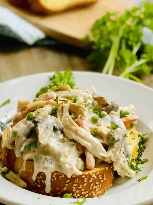 Open-faced turkey a la king served on toasted bread with creamy sauce, peas, carrots, and mushrooms — a classic comfort food idea for what to make with Thanksgiving leftovers and one of the best easy turkey recipes for busy weeknights.