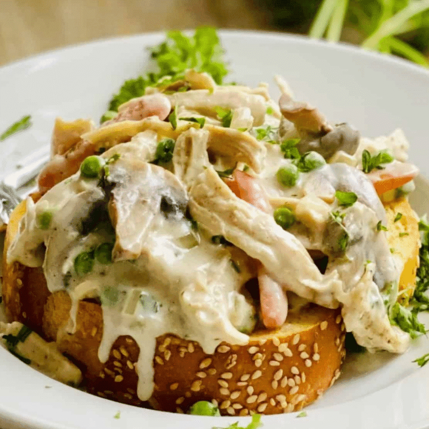 Open-faced turkey a la king served on toasted bread with creamy sauce, peas, carrots, and mushrooms — a classic comfort food idea for what to make with Thanksgiving leftovers and one of the best easy turkey recipes for busy weeknights.