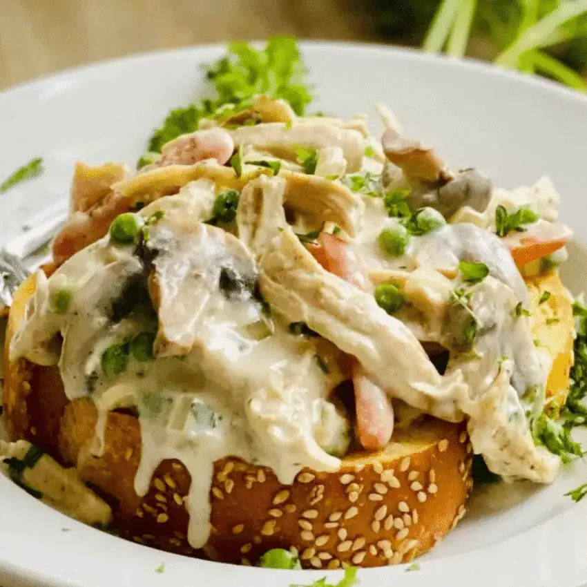 Open-faced turkey a la king served on toasted bread with creamy sauce, peas, carrots, and mushrooms — a classic comfort food idea for what to make with Thanksgiving leftovers and one of the best easy turkey recipes for busy weeknights.
