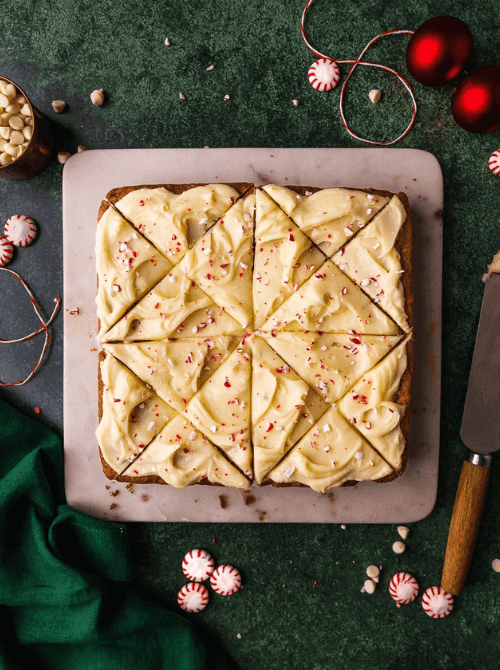 White chocolate peppermint blondies topped with frosting and crushed candy canes, a festive DIY Christmas gift and easy edible gift idea for holiday celebrations.