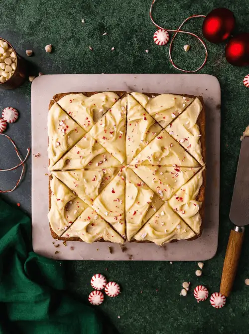 White chocolate peppermint blondies topped with frosting and crushed candy canes, a festive DIY Christmas gift and easy edible gift idea for holiday celebrations.