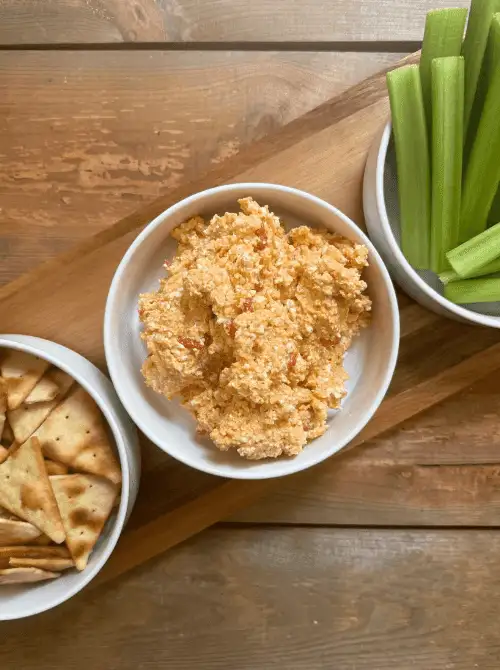 Southern pimento cheese dip served in a white bowl with crackers and celery, a classic addition to Party Dips for the Holidays and Cheesy Dips.
