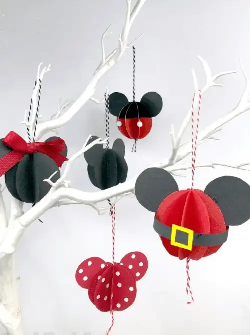 Dollar Store Christmas DIY decor Mickey and Minnie Mouse paper ornaments in black, red, and polka dot designs with hanging strings, displayed on a white branch tree.
