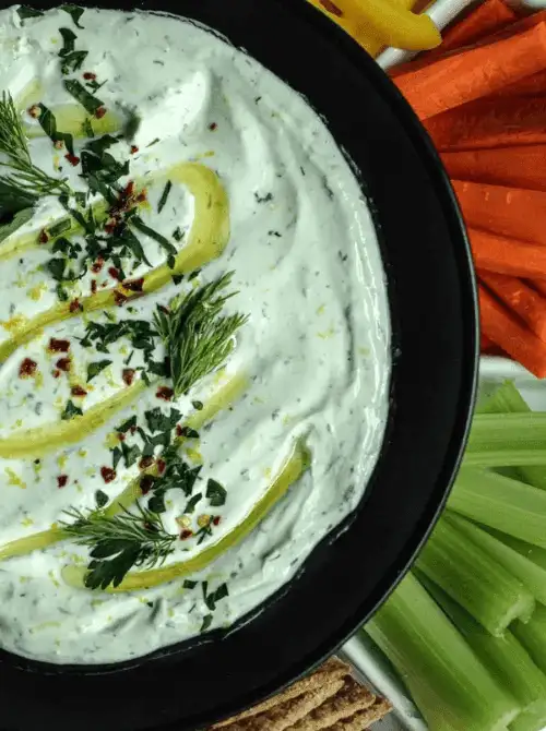 Creamy dill dip topped with fresh herbs and olive oil drizzle, served with celery, carrots, and crackers—an herby favorite for Party Dips for the Holidays and Cheesy Dips.