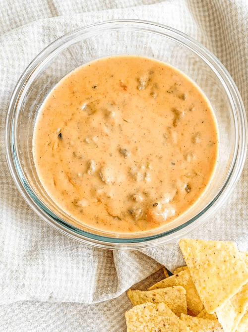Creamy homemade ranch dressing in a mason jar with a spoon, served with carrot and celery sticks—an easy favorite for Party Dips for the Holidays and Cheesy Dips.
