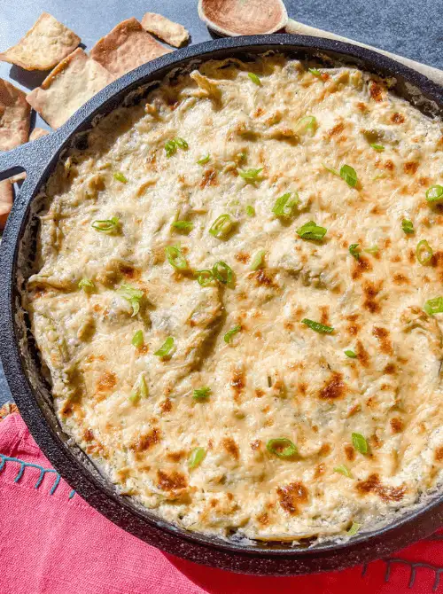Hot skillet artichoke dip baked until golden and topped with green onions, a savory favorite for Party Dips for the Holidays and Cheesy Dips.