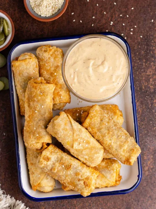Big Mac Egg Rolls served with creamy dipping sauce — a crispy, budget-friendly twist on a classic burger that makes the perfect easy finger food appetizer for Christmas party food ideas, game day gatherings, or holiday entertaining on a budget.