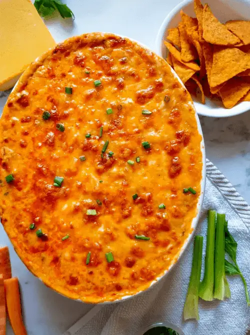 Golden baked buffalo chicken dip topped with green onions, served with chips and veggies, a bold favorite for Party Dips for the Holidays with spicy dips.