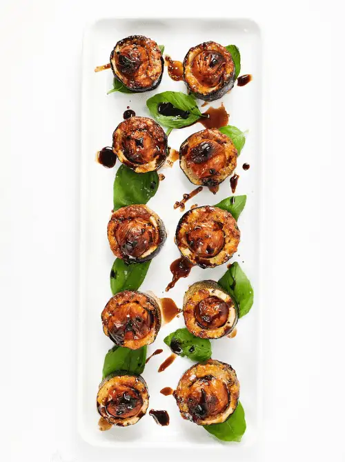 Caprese Zucchini Appetizers topped with roasted tomatoes, basil, and balsamic glaze — a light, low-carb twist for Christmas party food ideas that’s elegant, easy to make, and perfect for vegetarian holiday entertaining and budget-friendly finger food appetizers.