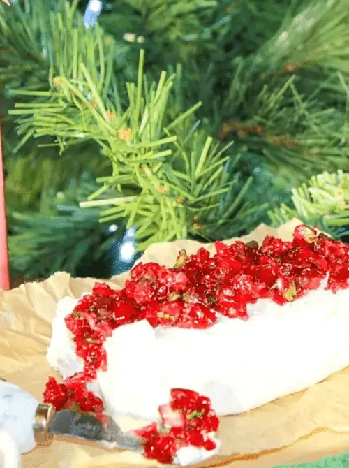 Cranberry jalapeño dip served over cream cheese with a holiday tree in the background, a colorful choice for Party Dips for the Holidays with Spicy Dips.