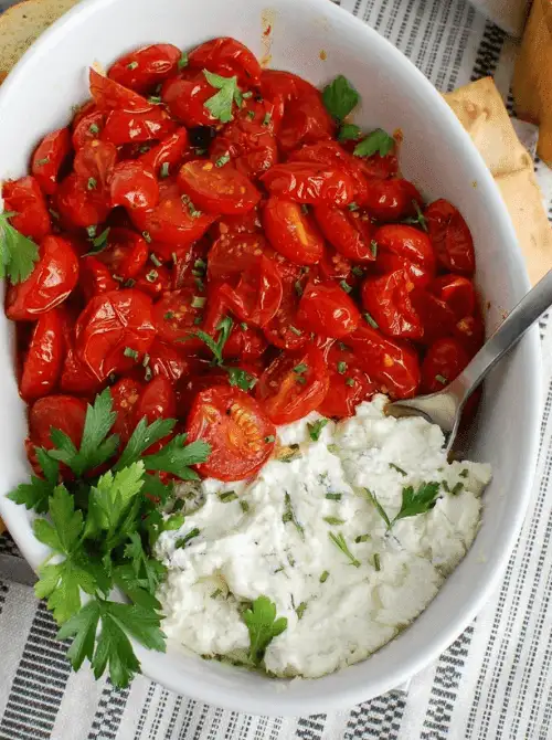 Goat cheese and roasted tomato dip topped with fresh herbs, a flavorful choice for Party Dips for the Holidays with Global Twists.