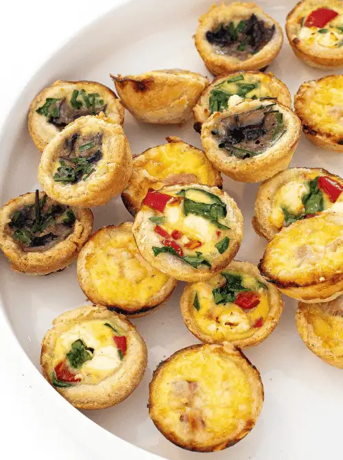 Mini Quiche Appetizers filled with colorful vegetables, cheese, and eggs — an easy make-ahead recipe for Christmas party food ideas that’s perfect for budget-friendly entertaining, festive brunches, and crowd-pleasing finger food appetizers during the holidays.