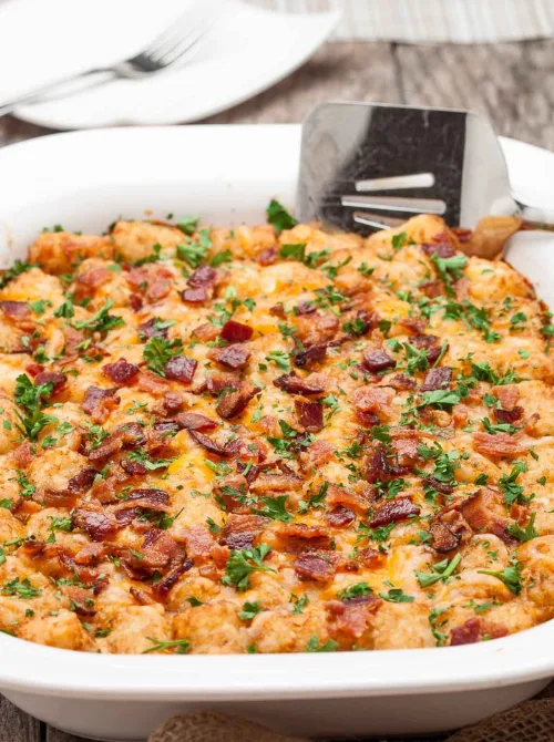 Golden tater tot breakfast casserole topped with bacon and melted cheese, a hearty and easy option for Christmas morning breakfast featured in casseroles and quiche recipes.