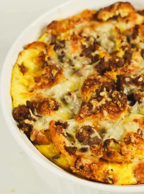 Golden baked sausage and cheese breakfast casserole in a white dish, perfect for Christmas morning breakfast and featured in casseroles and quiche recipes.