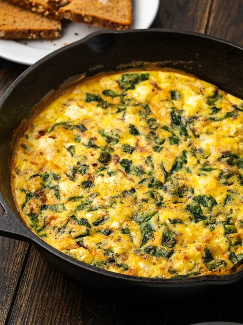 Skillet frittata with baby spinach, eggs, and cheese, a wholesome and colorful dish perfect for Christmas morning breakfast featured in casseroles and quiche recipes.