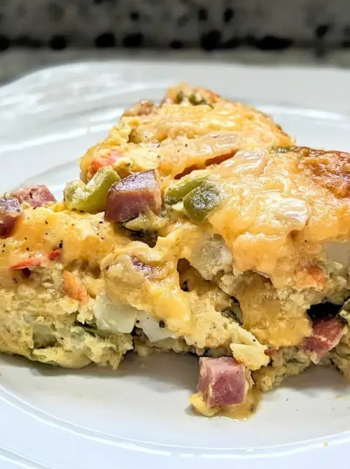 Slow cooker Denver omelet casserole with ham, cheese, and vegetables, a hearty make-ahead option for Christmas morning breakfast featured in casseroles and quiche recipes.