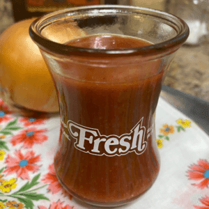 Close-up of sweet chili cranberry salad dressing made with cranberry sauce and onion in a clear glass jar