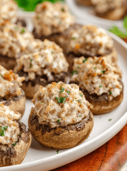Sausage stuffed mushrooms baked until golden, a cheap tailgate food and simple Super Bowl appetizer for a crowd.