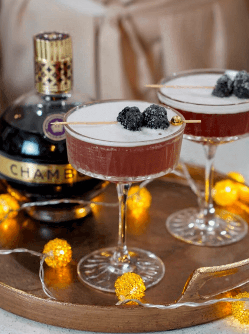Pink Cocktail Ideas for a Galentine’s Day Party featuring French martinis with Chambord, garnished with blackberries and served in coupe glasses