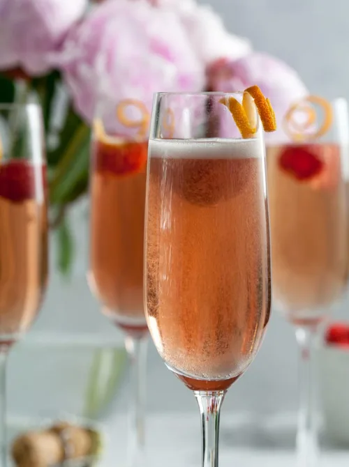 Pink Cocktail Ideas for a Galentine’s Day Party featuring sparkling champagne cocktails with citrus twist garnish in fluted glasses