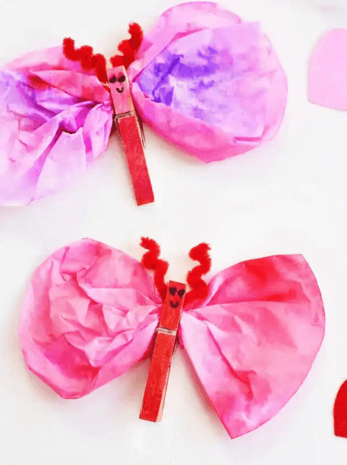 Coffee filter Valentine love bugs made with clothespins and tissue wings, Valentine’s DIY craft on a Dollar Tree budget.