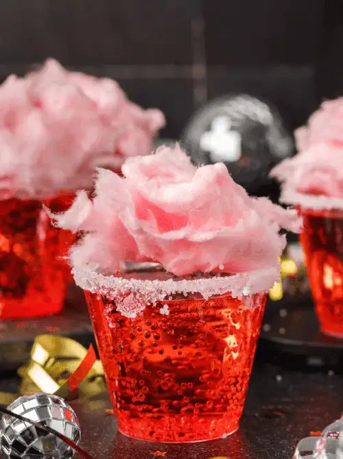 Close-up of cotton candy mocktails served for a Galantine's Day Party, showcasing easy mocktail ideas with sparkling pink drinks topped with fluffy cotton candy.