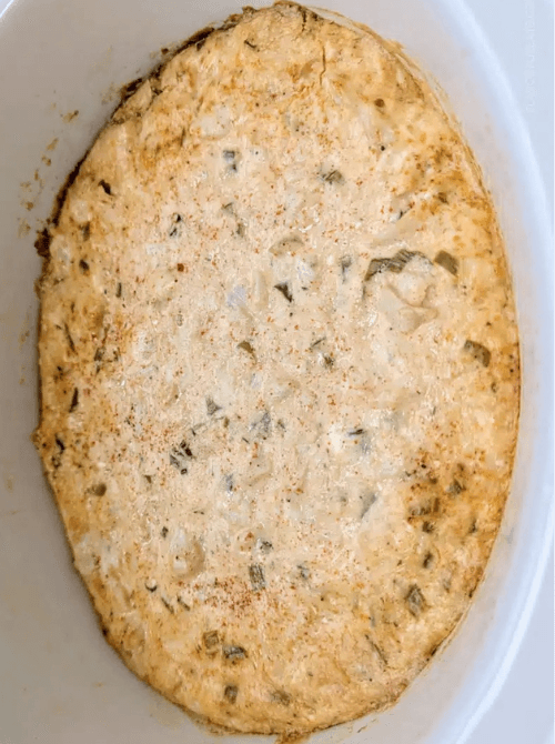 Creamy jalapeño chicken dip baked in a white casserole dish, featured in easy crock pot recipes for a last minute Super Bowl party.