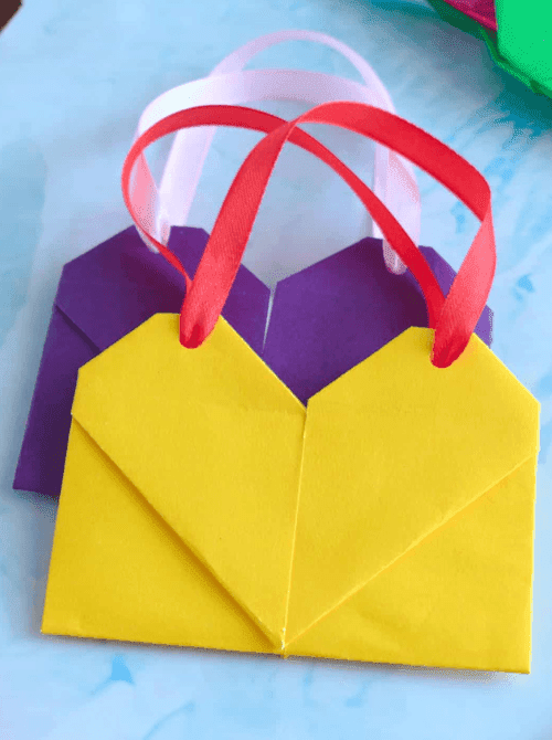 Heart-shaped paper gift bags with ribbon handles, Valentine’s DIY crafts made on a Dollar Tree budget.