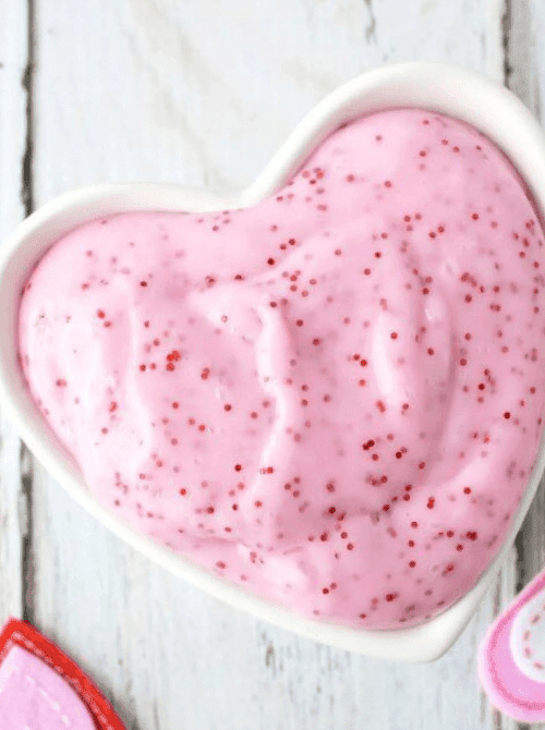 Pink Valentine slime with sprinkles in a heart-shaped bowl, Valentine’s DIY craft made on a Dollar Tree budget.