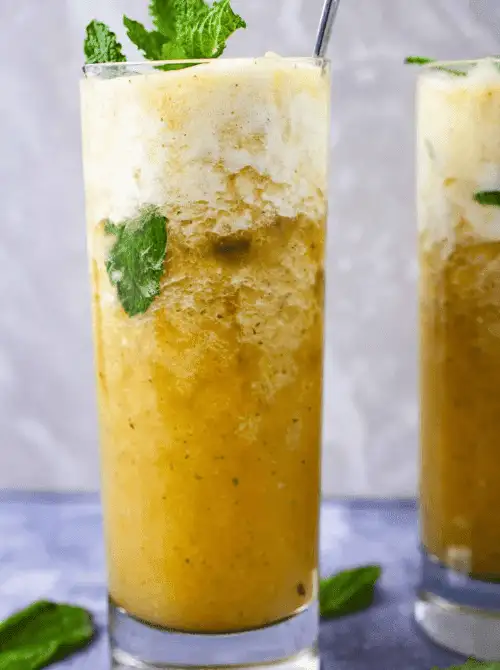 Close-up of a pineapple mojito mocktail served for a Galantine's Day Party, showcasing easy mocktail ideas with fresh mint and frothy layers in a tall glass.