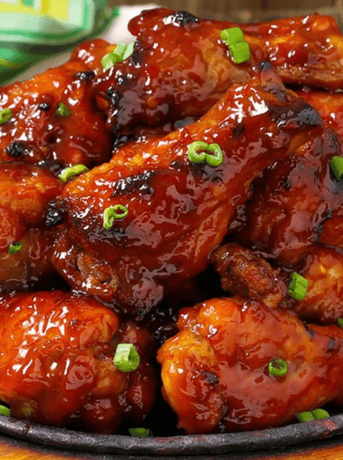 Sweet and spicy barbecue chicken wings glazed in sauce and topped with green onions, part of easy crock pot recipes for a last minute Super Bowl party.