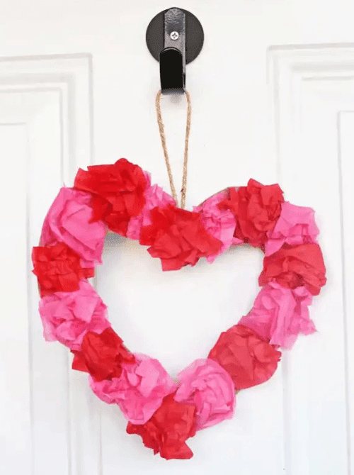 Heart-shaped tissue paper wreath for Valentine’s Day, easy Valentine’s DIY craft using Dollar Tree supplies.