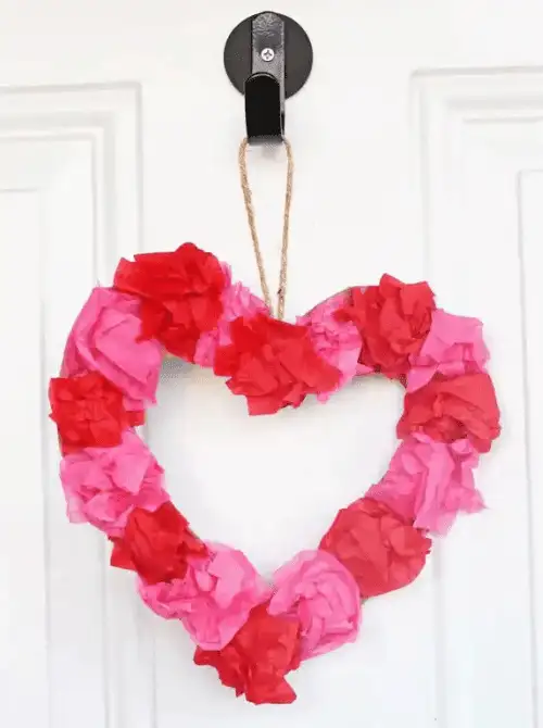 Heart-shaped tissue paper wreath for Valentine’s Day, easy Valentine’s DIY craft using Dollar Tree supplies.