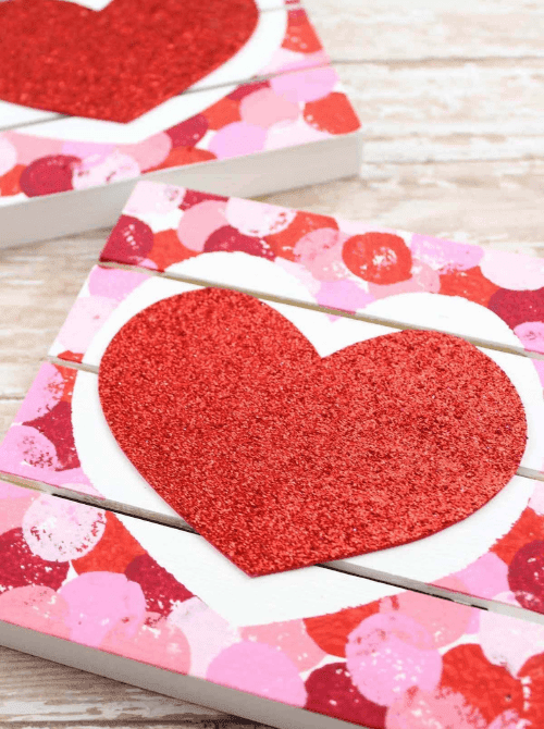 Glitter heart wooden photo blocks painted in pink and red, Valentine’s DIY crafts made on a Dollar Tree budget.