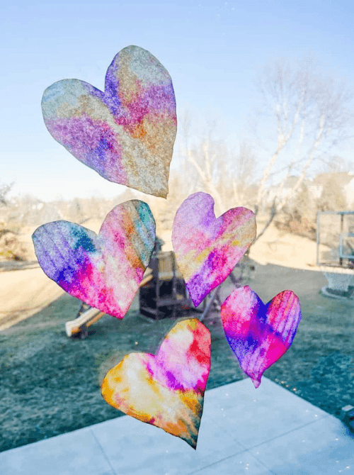 DIY Valentine coffee filter hearts dyed in rainbow colors, budget-friendly Valentine’s DIY decor.